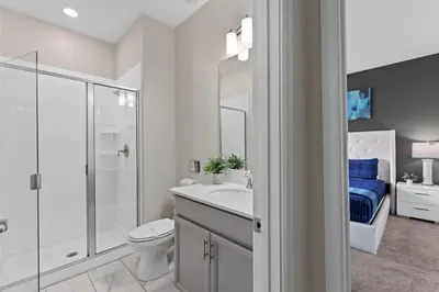 a white bathroom with a toilet and a shower at Disney Getaway Townhouse with Private Pool. Book Now SLR504 in Kissimmee