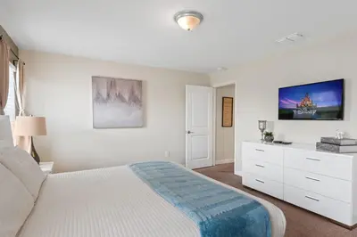 a white bedroom with a bed and a dresser at Disney Getaway Townhouse with Private Pool. Book Now SLR504 in Kissimmee