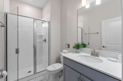 a white bathroom with a toilet and a shower at Disney Getaway Townhouse with Private Pool. Book Now SLR504 in Kissimmee