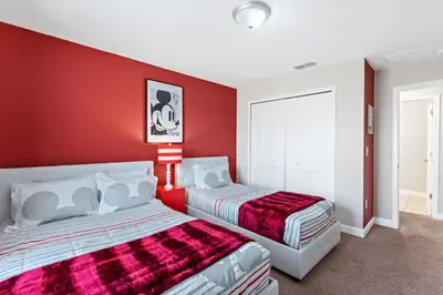 a red room with two beds and a red wall at Disney Getaway Townhouse with Private Pool. Book Now SLR504 in Kissimmee
