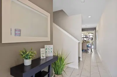 a hallway with a black table and a picture on the wall at Disney Getaway Townhouse with Private Pool. Book Now SLR504 in Kissimmee