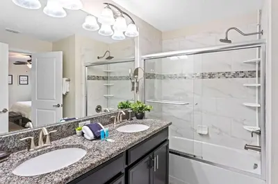 a bathroom with two sinks and a shower at Disney Getaway Private Pool Themed Bedrooms. Book Now SLR505 in Kissimmee