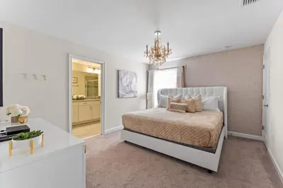a white bedroom with a bed and a chandelier at Disney Getaway Private Pool Themed Bedrooms. Book Now SLR499 in Kissimmee