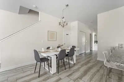 a white dining room with a table and chairs at Disney Getaway Villa with Private Pool Hot Tub. Book Now SLR502 in Kissimmee