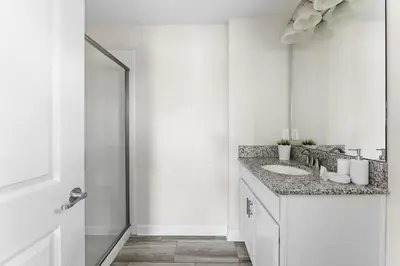 a white bathroom with two sinks and a shower at Disney Getaway Villa with Private Pool Hot Tub. Book Now SLR502 in Kissimmee