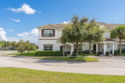 a house with a tree in front of a street at Disney Getaway Villa with Private Pool Hot Tub. Book Now SLR502 in Kissimmee
