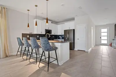 a kitchen with a island with bar stools at Disney Private Pool Game Room Themed Bedrooms. Book Now SLR493 in Kissimmee