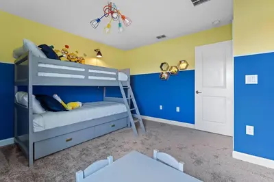 a bedroom with a bunk bed with blue walls at Disney Private Pool Game Room Themed Bedrooms. Book Now SLR493 in Kissimmee