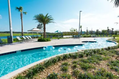 a swimming pool at a resort with chairs and palm trees at Disney Private Pool Game Room Themed Bedrooms. Book Now SLR493 in Kissimmee