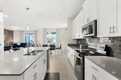 a large kitchen with white cabinets and appliances at Disney Private Pool Hot Tub Themed Bedrooms. Book Now SLR494 in Kissimmee