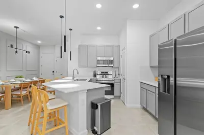 a kitchen with white cabinets and a table and chairs at Disney Getaway Private Pool Themed Bedrooms. Book Now PG54 in Orlando