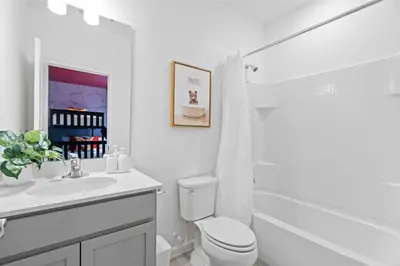 a white bathroom with a toilet and a sink at Disney Getaway Private Pool Themed Bedrooms. Book Now PG54 in Orlando