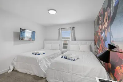 a bedroom with two beds and a tv on the wall at Disney Getaway Private Pool Themed Bedrooms. Book Now SLR370 in Kissimmee