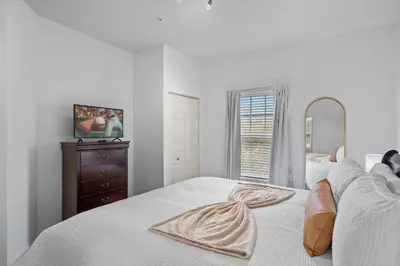 a white bedroom with a bed with a mirror and a dresser at Disney Getaway Private Pool Themed Bedrooms. Book Now WLV5 in Kissimmee