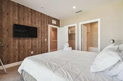 a bedroom with a large white bed and a tv at Disney Getaway Townhouse with Private Pool. Book Now MVV18 in Orlando