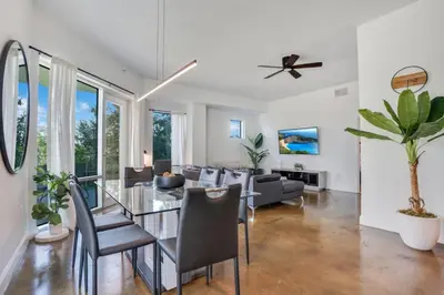 a living room with a glass table and chairs at 3 bedroom Corner Suite in Orlando