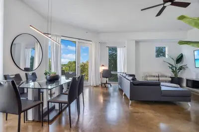 a living room with a dining table and a mirror at 3 bedroom Corner Suite in Orlando