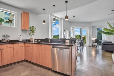 a kitchen with wooden cabinets and a stainless steel dishwasher at 3 bedroom Corner Suite in Orlando