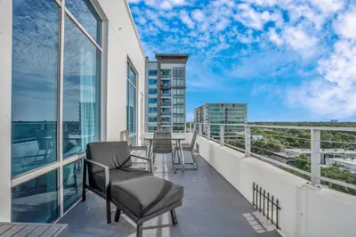 a balcony with chairs and tables on a building at 2 Bdrm Penthouse with Billiards in Orlando