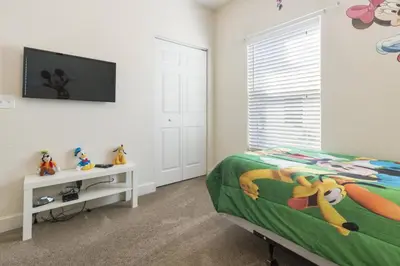 a bedroom with a bed and a flat screen tv at Cozy Family House near Disney 8108 in Kissimmee