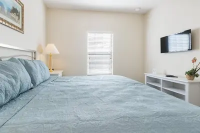 a bedroom with a large bed and a television at Cozy Family House near Disney 8108 in Kissimmee