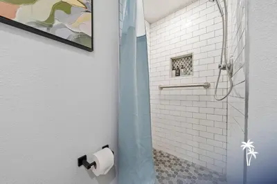 a bathroom with a shower with a toilet paper roll at Volcano View 2 Bed 2 Bath Condo with Balcony in Orlando