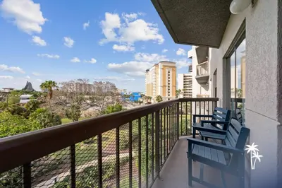 two blue chairs sitting on a balcony with a view at Volcano View 2 Bed 2 Bath Condo with Balcony in Orlando