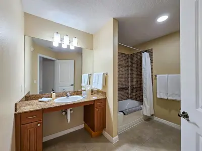 a bathroom with a sink and a bath tub at 2BR 2BA Grand Duo Suite Sleeps 8 Near Universal and I Drive in Orlando