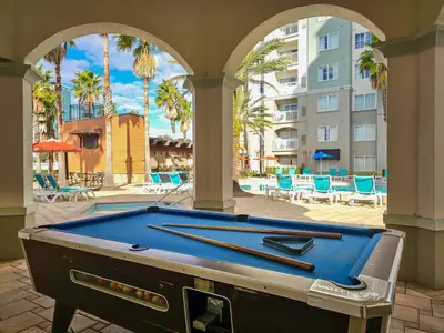 a pool table in front of a building with palm trees at 2BR 2BA Grand Duo Suite Sleeps 8 Near Universal and I Drive in Orlando