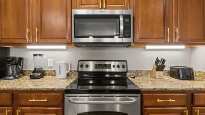 a kitchen with a stove and a microwave at Near Universal's Epic Universe Suite -3BR in Orlando