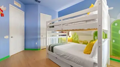 a childs bedroom with a bunk bed and blue walls at Near Universal's Epic Universe Suite -3BR in Orlando