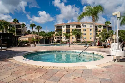 a pool with a water slide in a courtyard with buildings at WorldQuest Orlando Resort in Orlando