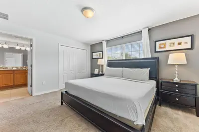 a bedroom with a large bed and a window at 8847 Candy Palm Rd in Kissimmee