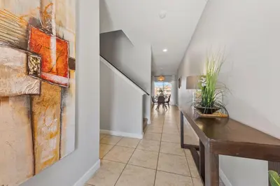 a hallway with white walls and a table with plants at 8847 Candy Palm Rd in Kissimmee
