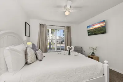 a bedroom with a white bed and a window at Single Story Villa with Pool Views and Family Fun in Orlando