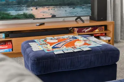 an ottoman in front of a television in a living room at Single Story Villa with Pool Views and Family Fun in Orlando