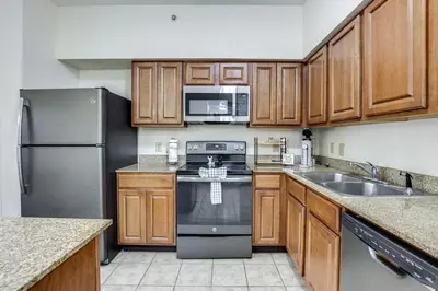 a kitchen with stainless steel appliances and wooden cabinets at Poolside Oasis 7 Mi to Disney and Universal in Orlando
