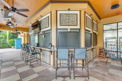 a patio with chairs and a bar on a building at Poolside Oasis 7 Mi to Disney and Universal in Orlando