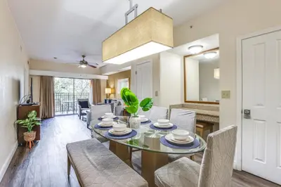 a dining room and living room with a table and chairs at Poolside Oasis 7 Mi to Disney and Universal in Orlando