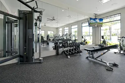a gym with several treadmills and cardio machines at Epic Paradiso Mansion-Pool,Game Room,Theater-4 in Orlando