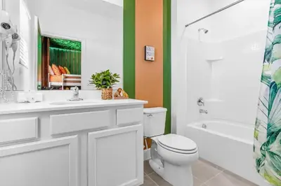 a bathroom with a toilet and a sink and a tub at Epic Paradiso Mansion-Pool,Game Room,Theater-4 in Orlando