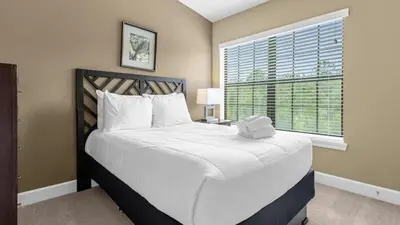 a bedroom with a large white bed with a window at Sunny Summer Magic - Stay in TownHome by Disney in Orlando