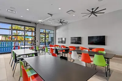 a dining room with tables and colorful chairs at Casa Luxo 5 Suítes | Perto da Epic Universe in Orlando