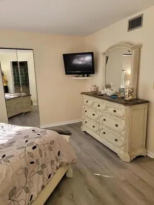 a bedroom with a bed and a dresser with a mirror at Cozy 2 bedroom Orlando apartment in Orlando