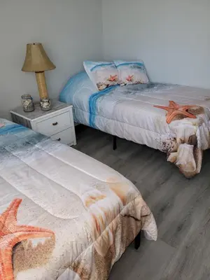 a bedroom with two beds and a table with a lamp at Cozy 2 bedroom Orlando apartment in Orlando