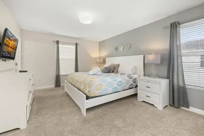 a bedroom with a bed and a dresser and window at Luxe Lakeview Private Pool SPA 10 Min Disney in Kissimmee