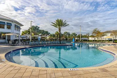 a large swimming pool with chairs and umbrellas at Luxe Lakeview Private Pool SPA 10 Min Disney in Kissimmee