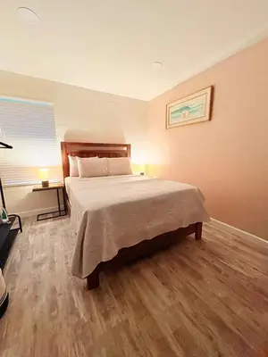 a bedroom with a large bed with a wooden floor at Modern Studio with Exterior Independent Entrance in Orlando