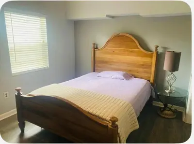 a bedroom with a large wooden bed and a window at Light and Easy Getaways in Orlando