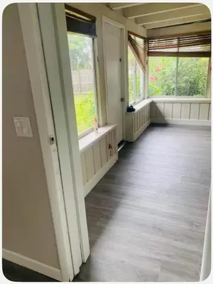 an empty room with two windows and a wooden floor at Light and Easy Getaways in Orlando